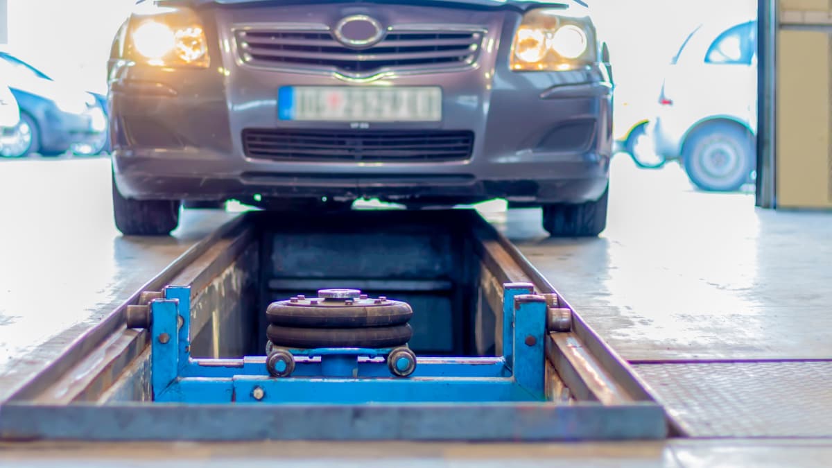 A silver car being moved into a vehicle service lane