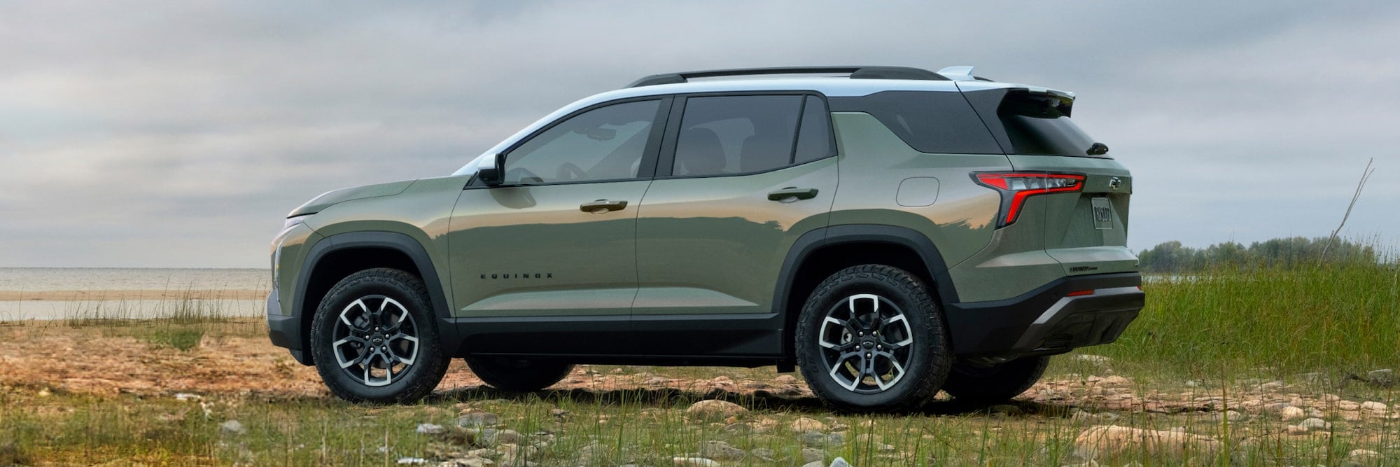 A green Chevrolet Equinox parked at a beach