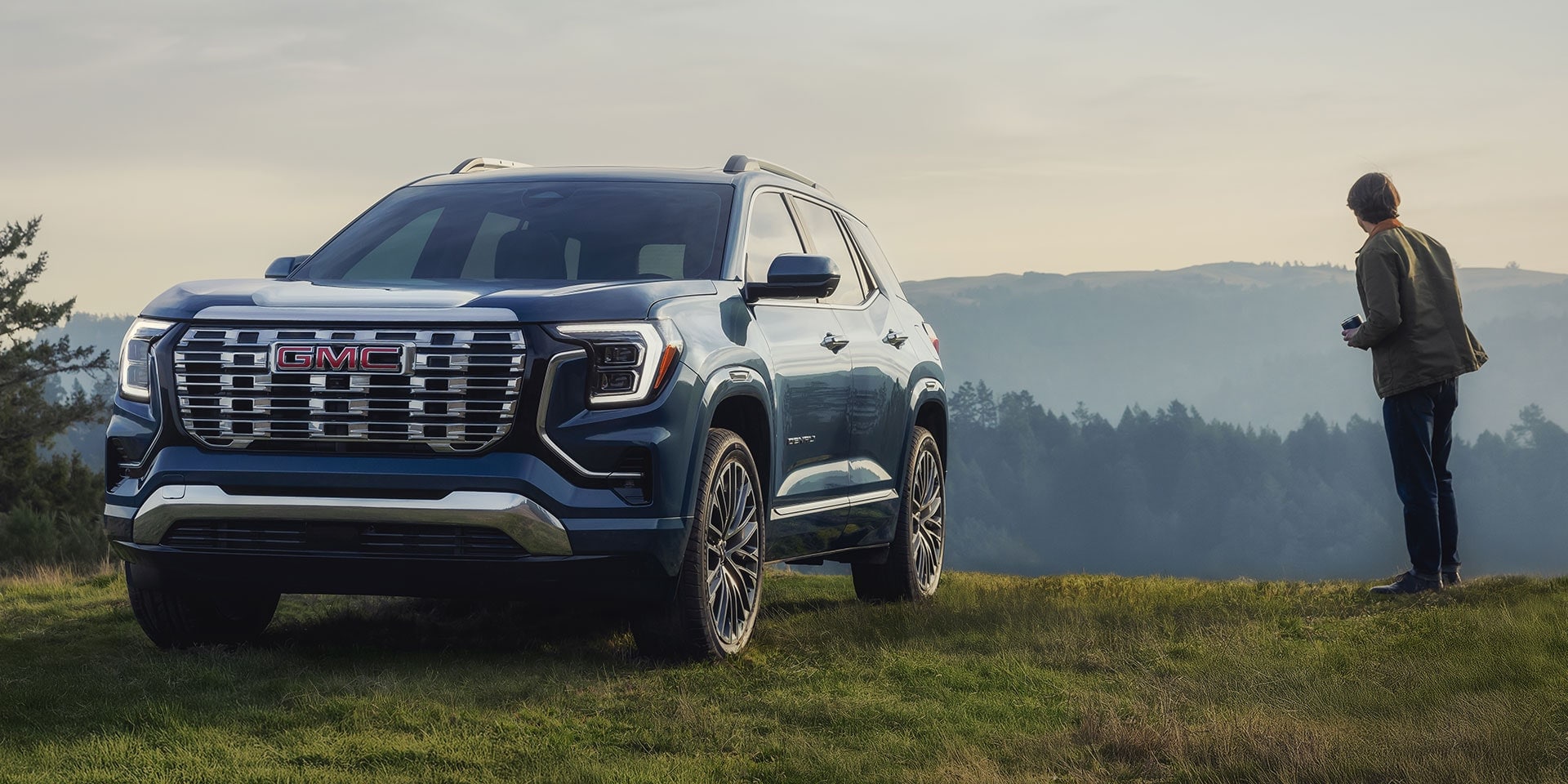 A blue GMC Terrain facing away from the edge of a cliff