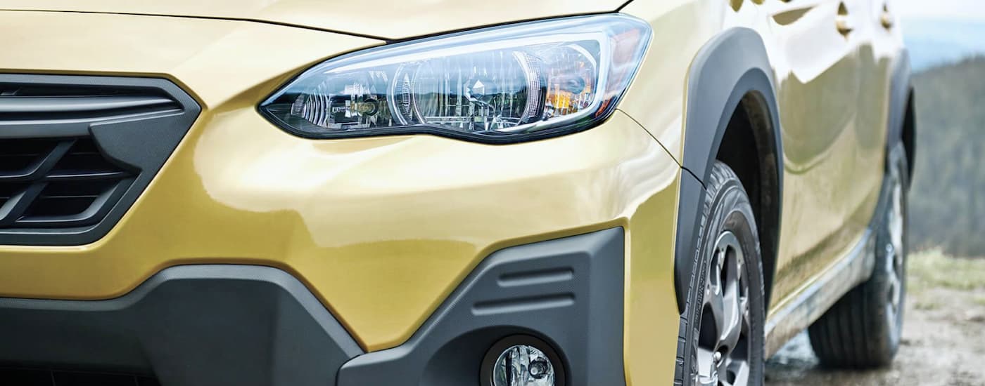  The close up of a yellow 2022 Subaru Crosstrek Sport shows the headlight.