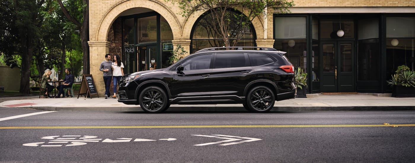 A black 2022 Subaru Ascent is shown from the side parked on a city street.
