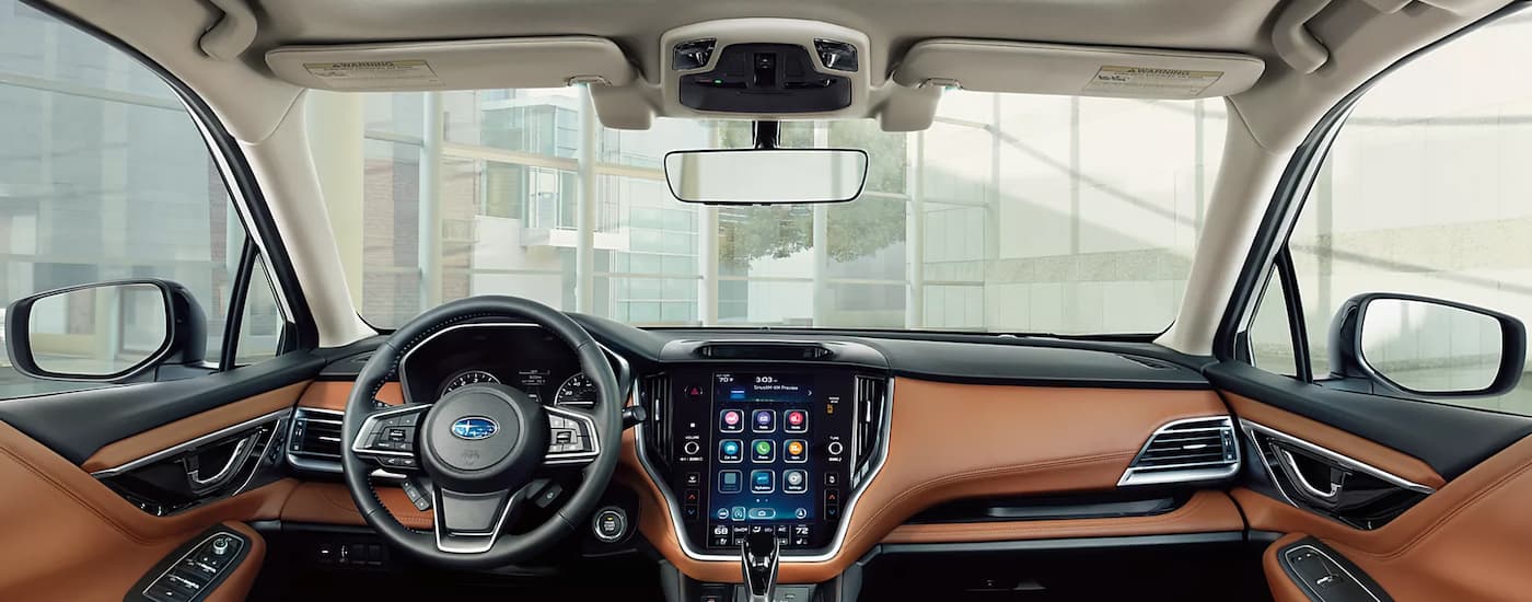 The black and brown interior of a 2022 Subaru Legacy Touring XT shows the steering wheel and center console.