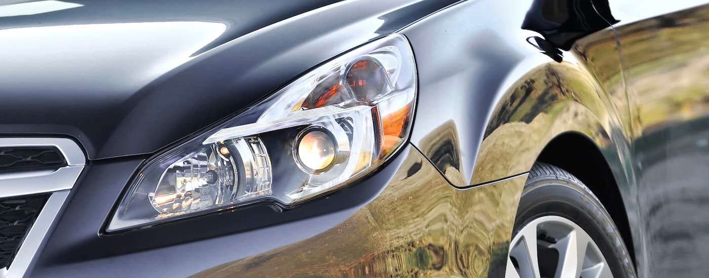 A close up shows the headlight on a grey 2014 Subaru Legacy.