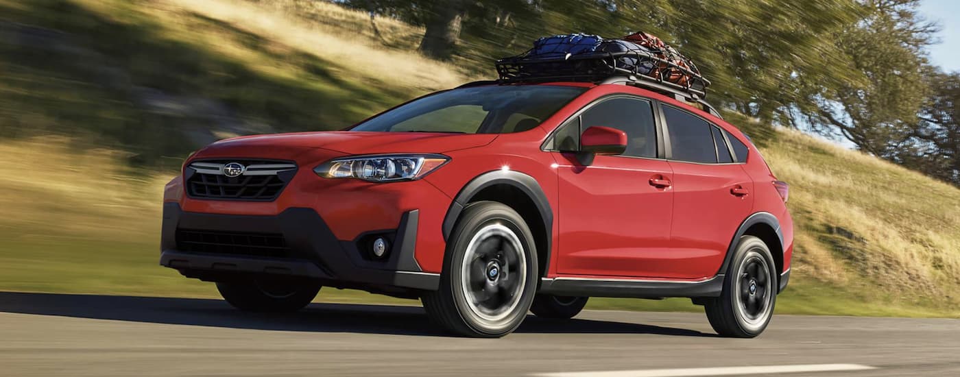 A red 2022 Subaru Crosstrek Premium is shown from the side driving on an open road.