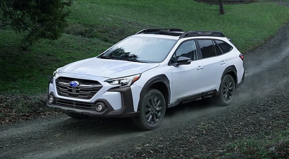 A white 2023 Subaru Outback is shown from the side after leaving a Subaru dealer.