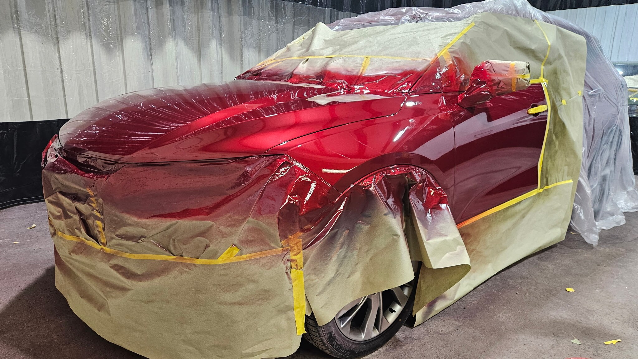 Technician performing color-matched paint repair on a vehicle at Car City Wholesale's body shop in Shawnee, KS