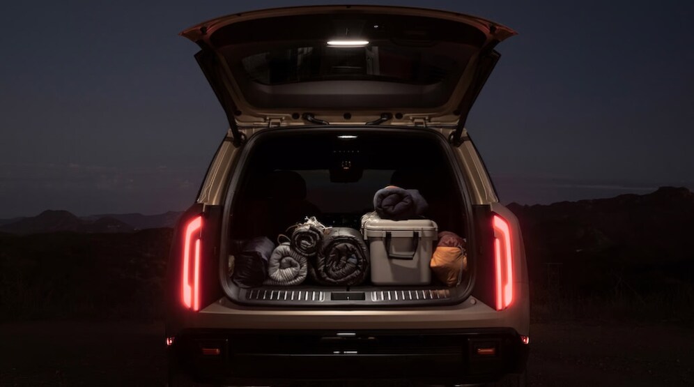 The cargo area of a 2026 Kia Telluride SUV, packed with sleeping bags and camping gear