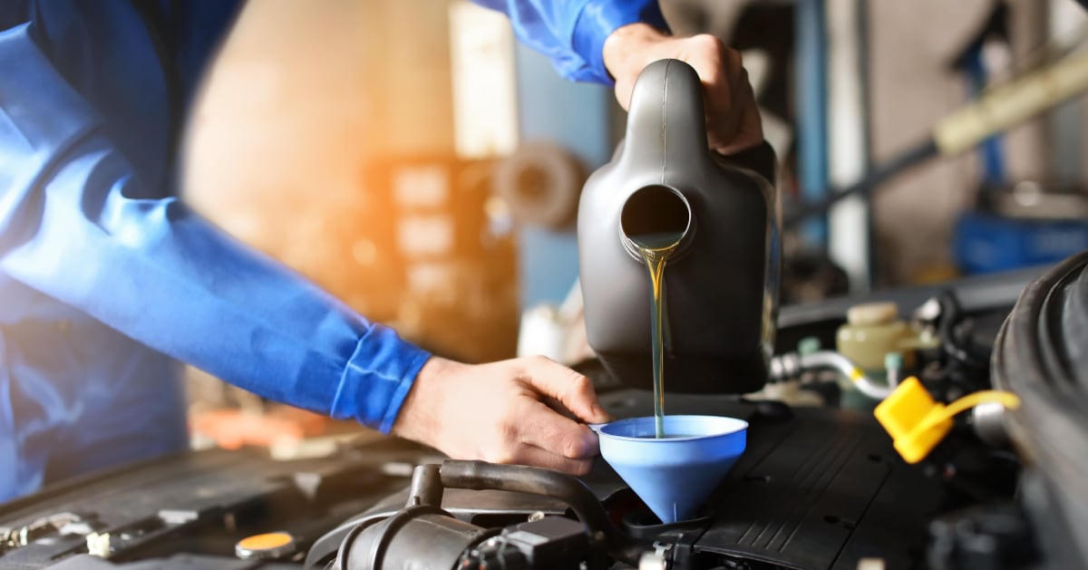 a man puring new engine oil to a car using a funnel (2).jpg