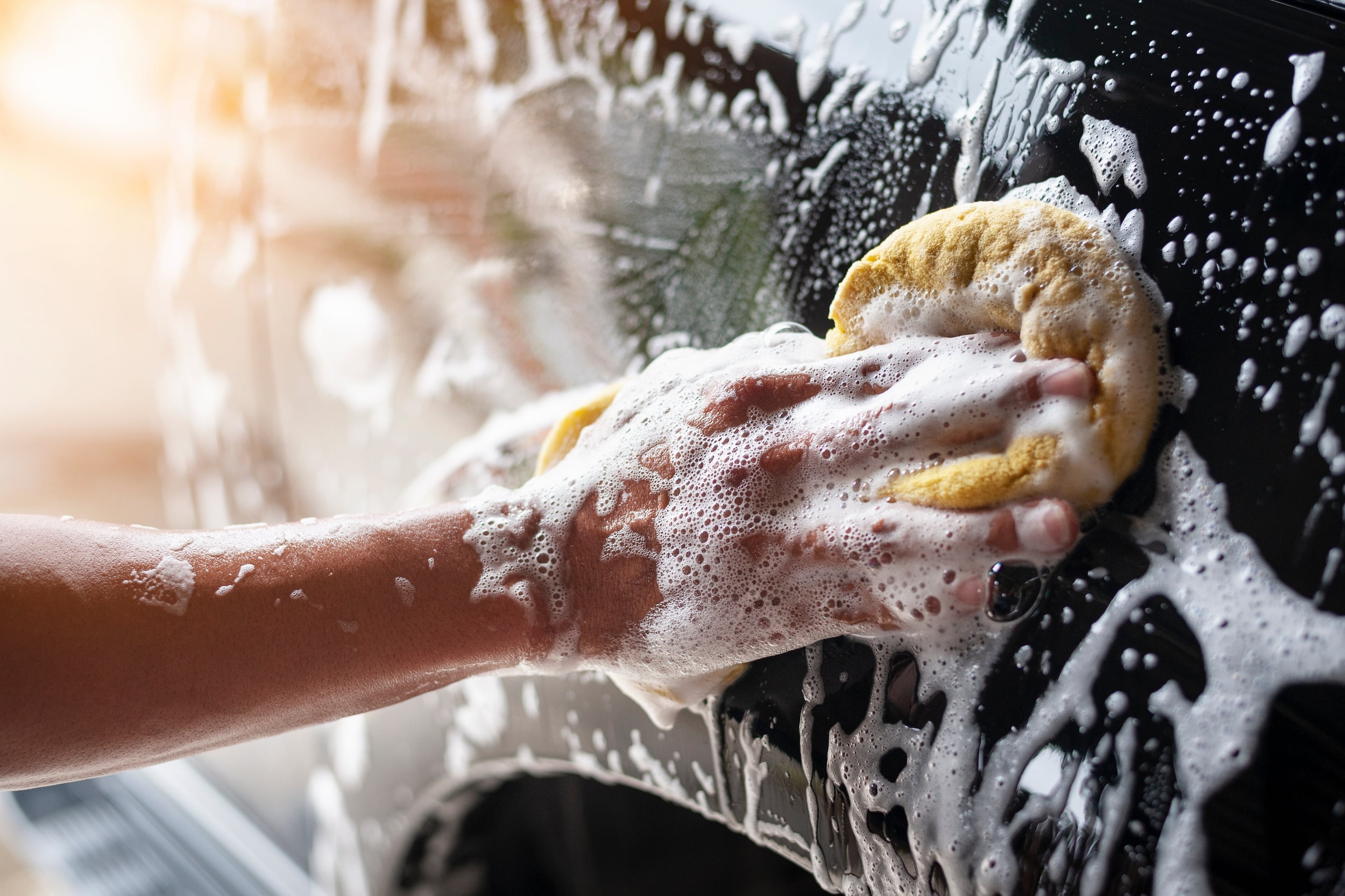 someone%20washing%20a%20car%20with%20a%20yellow%20sponge%20and%20soapy%20water.jpeg