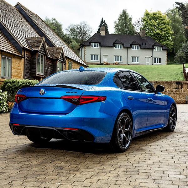 Blue Alfa Romeo Giulia in the coutryside from the rear.