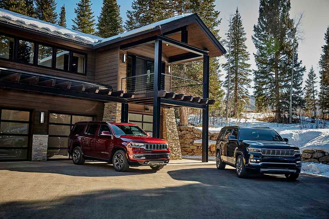 The two Jeep Grand Wagoneer and 2022 Wagoneer parked in the courtyard of a chalet during the winter season