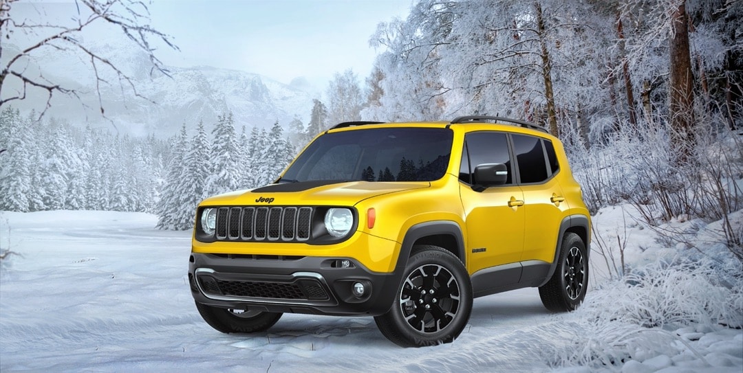 Front 3/4 view of the Solar Yellow 2023 Jeep Renegade parked outside in the winter season.
