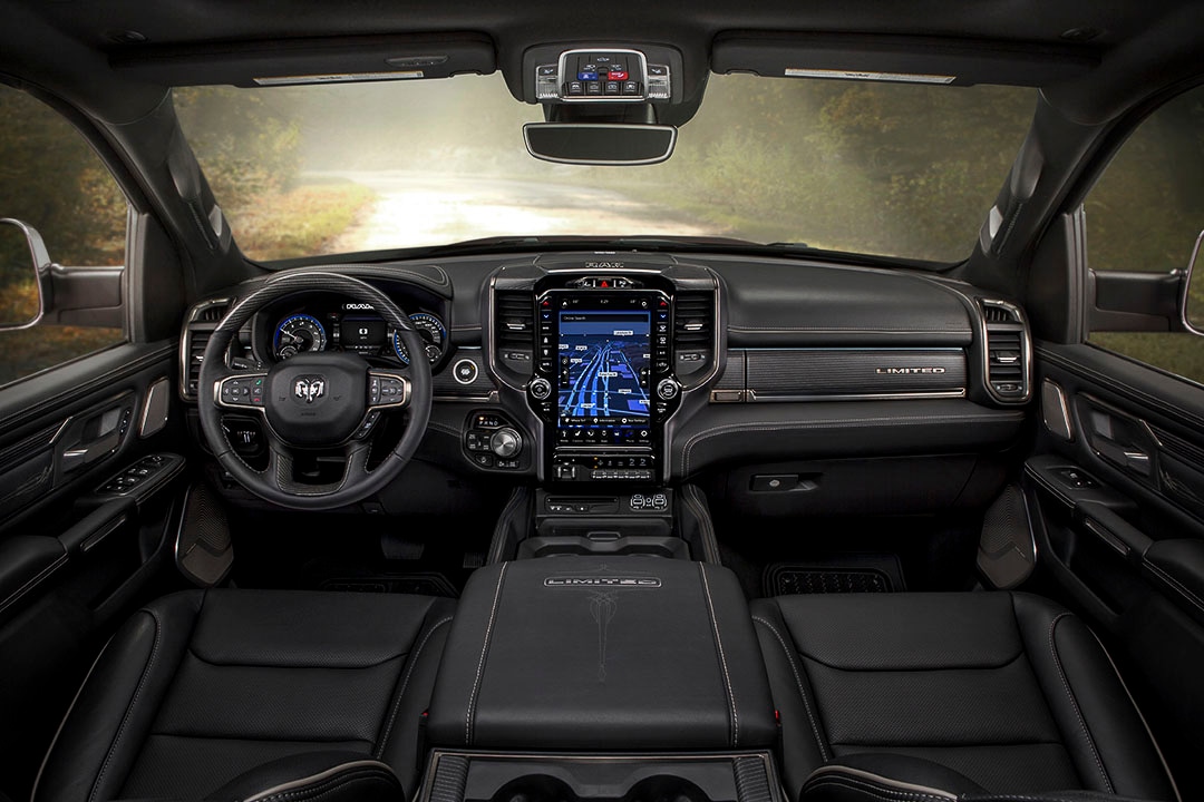 view of the front row seats inside of the 2021 RAM 1500 Limited with the central dashboard and steering wheel