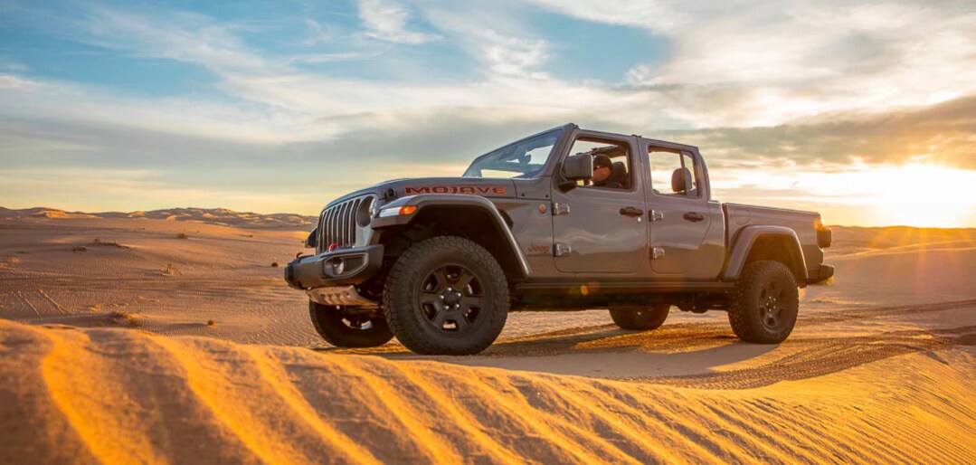 Vue latérale d'un Jeep Gladiator Mojave 2022 sur une dune de sable