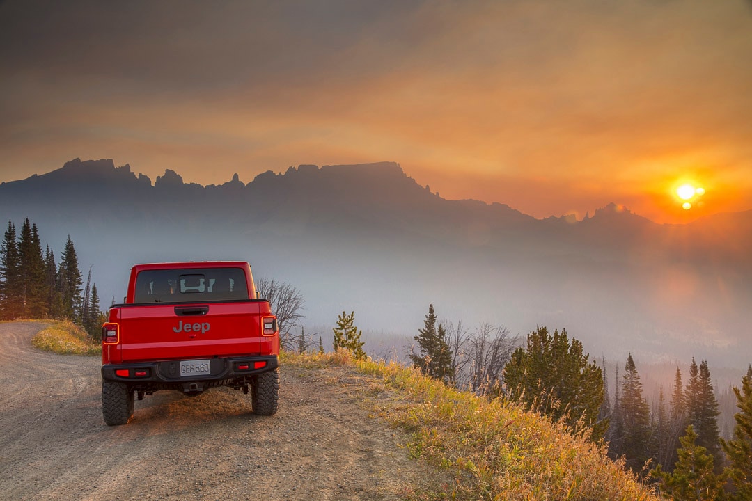 Rear view of a 2022 Jeep Gladiator on a country road at dusk