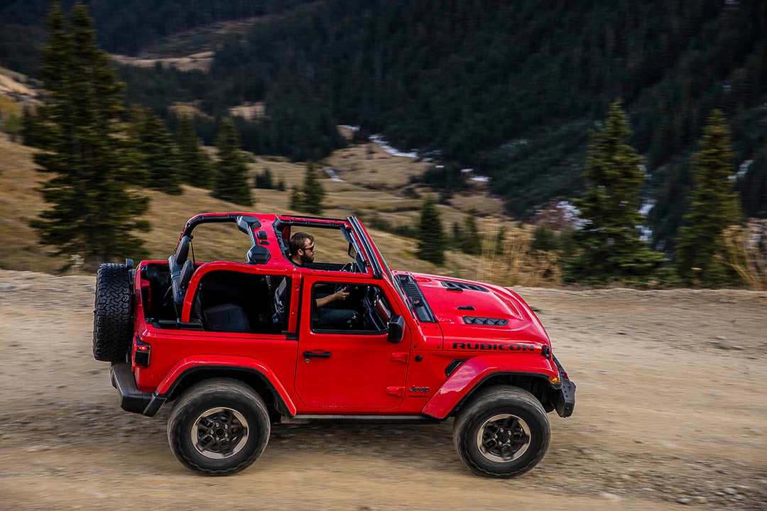 vue latérale du Jeep Wrangler 2021 sur un sentier montagneux