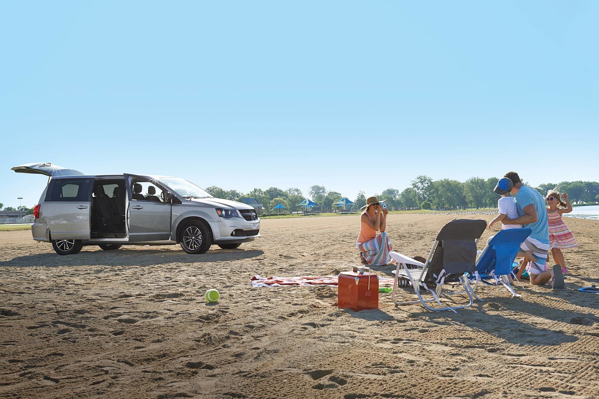 une famille campante sur la plage avec la Dodge Grand Caravan 2019 gris pendant la saison d'été