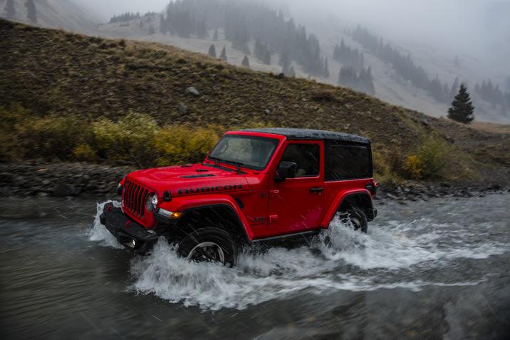 Jeep Wrangler Rubicon 2018 rouge conduisant dans une rivière dans la nature
