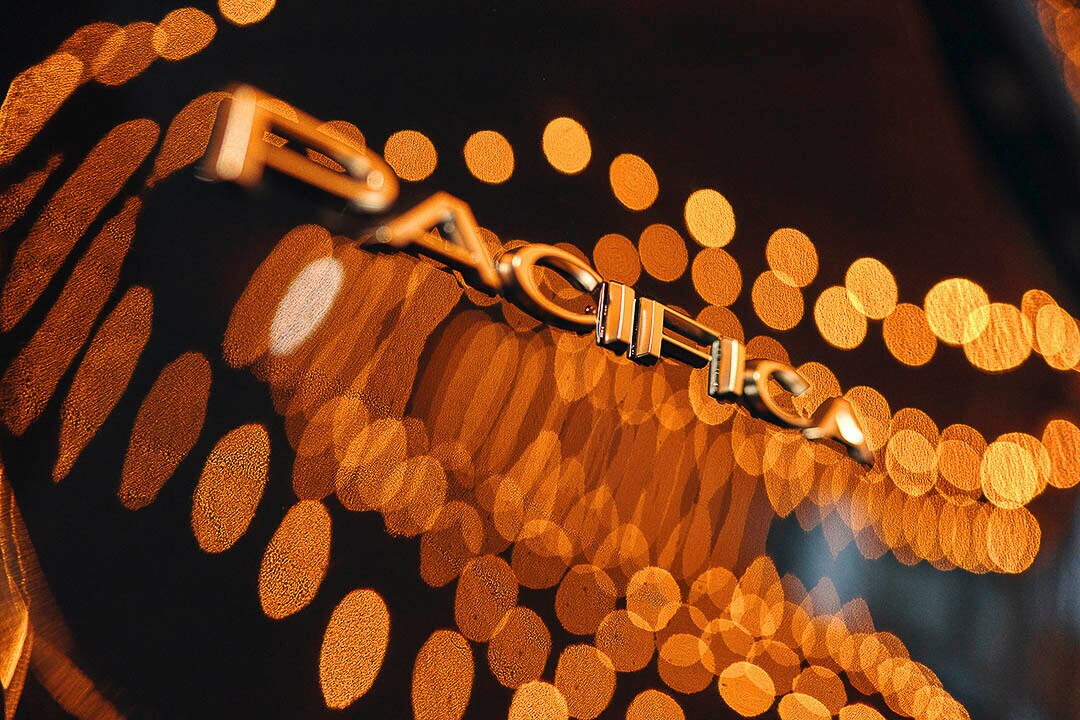 Les lettres PACIFICA illuminées par un reflet de lumières orange