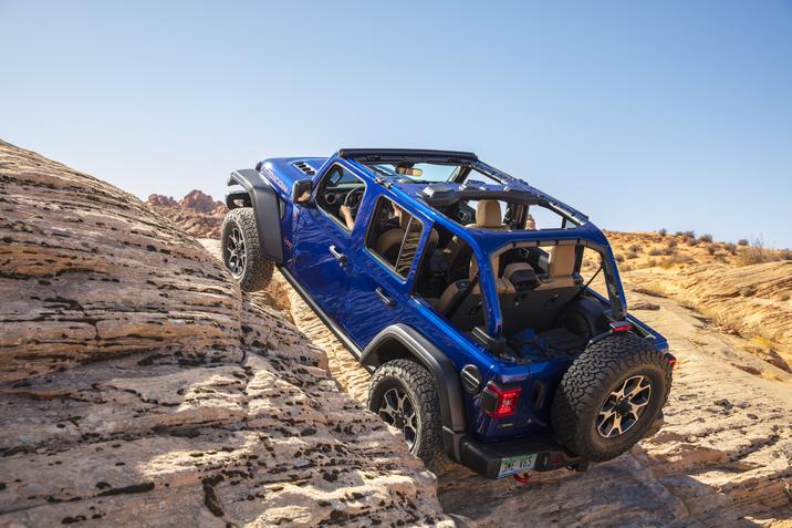 Vue trois quart arrière du Jeep Wrangler 2020 escaladant une surface rocheuse