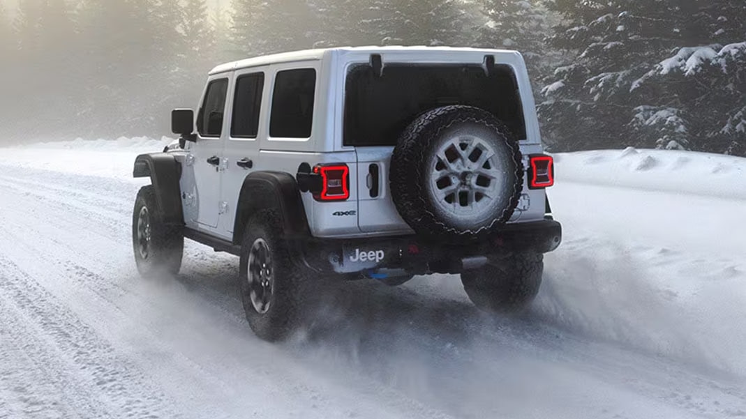 A Jeep Wrangler driving in the snow