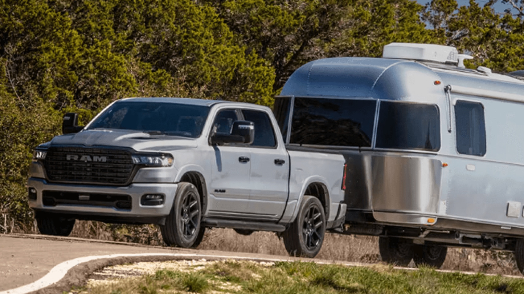 Silver Ram 1500 towing a silver camper trailer