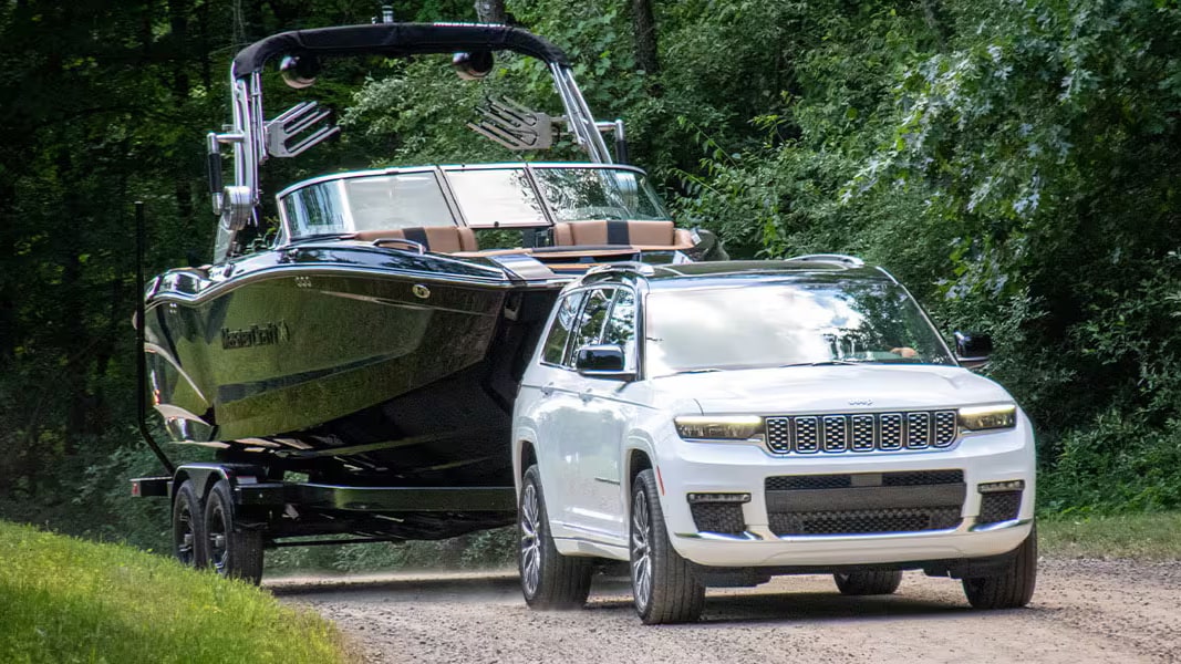 A Bright White Jeep Grand Cherokee towing a speedboat
