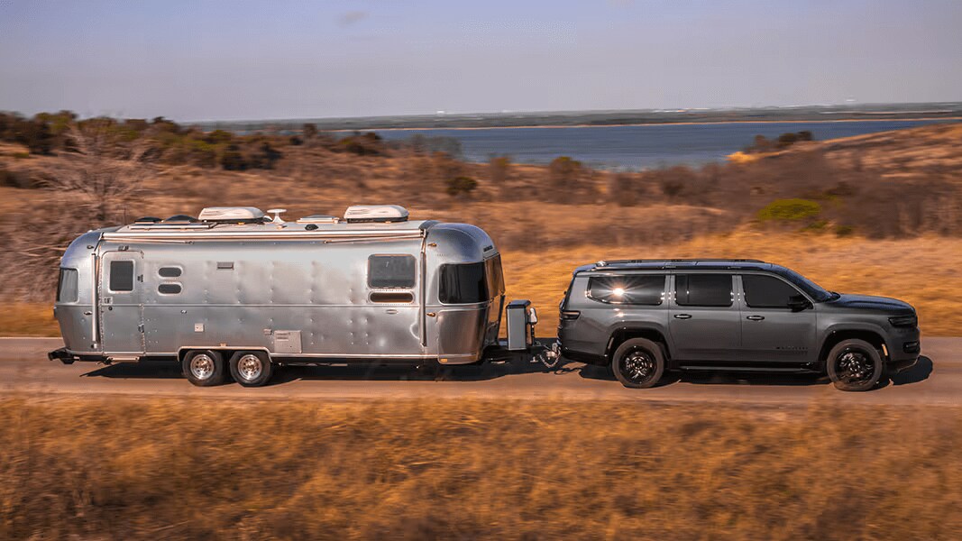 Learn about the performance features of the Jeep Wagoneer Action shot of a Jeep Wagoneer towing an RV trailer
