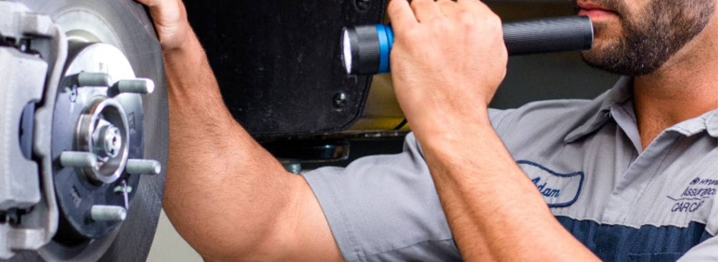 mechanic i=nspecting brake pads change on a Hyundai