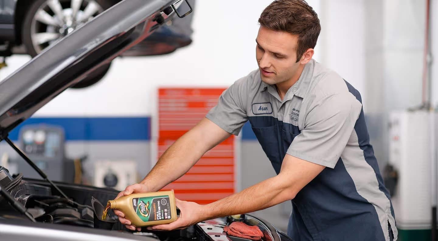 Mechanic doing oil change on Hyundai