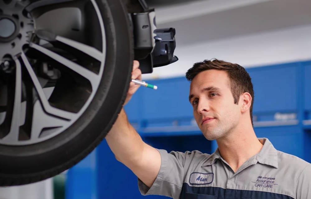 Mechanic looking at a tire while the car is on a lift