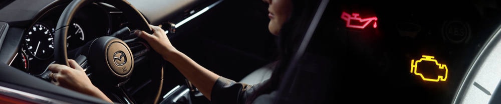 Women driving a car with warning lights on dashboard