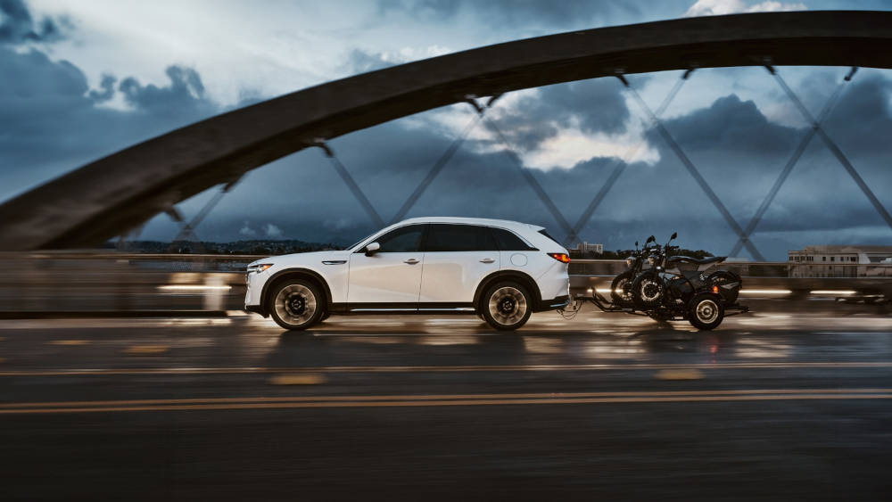 2025 Mazda CX-90 driving over a bridge