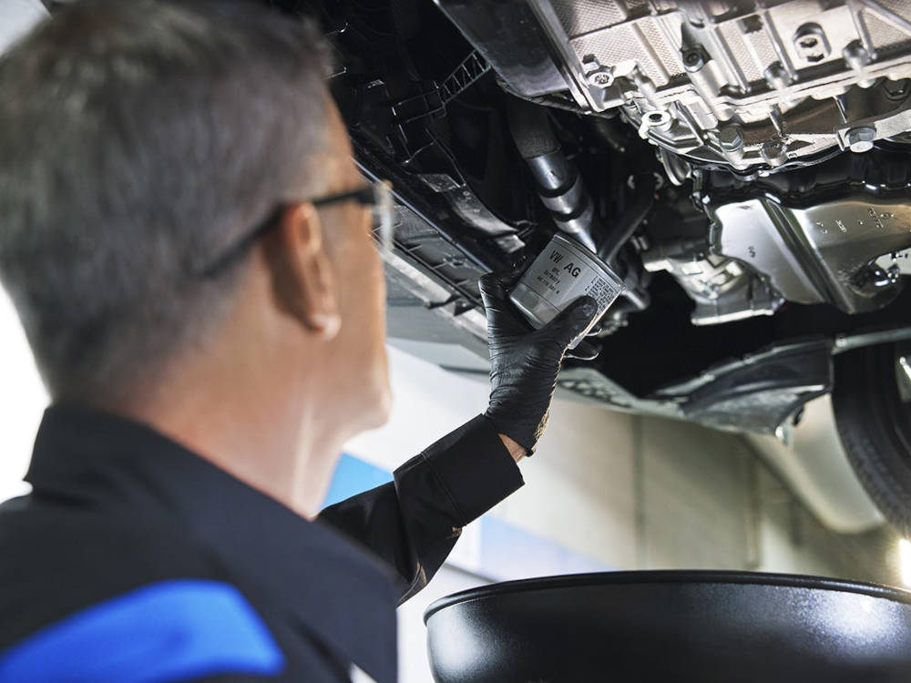 mechanic changing oil filter on Volkswagen