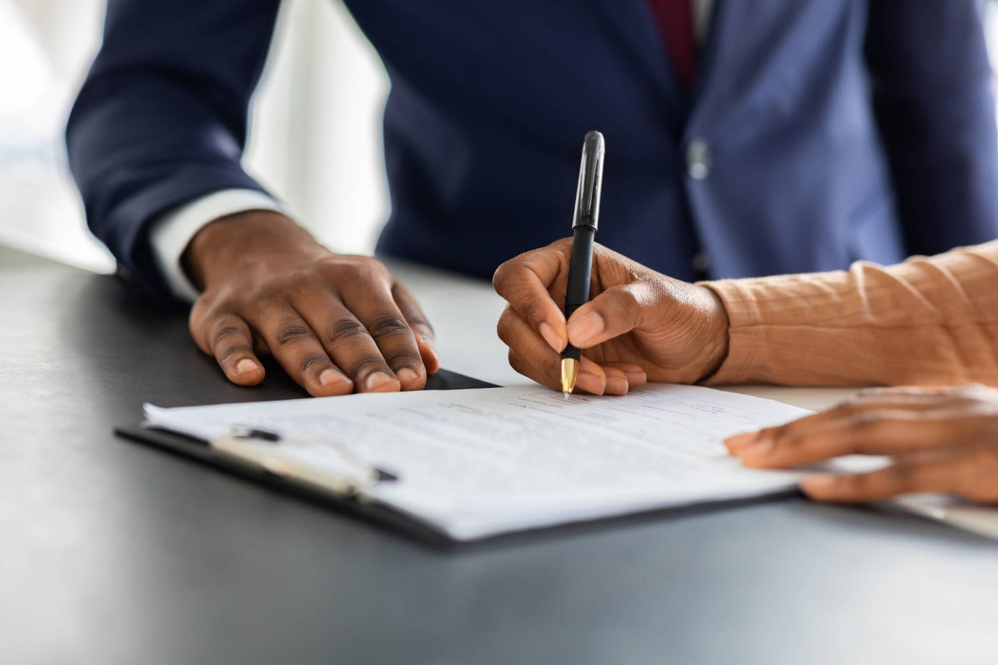 Female Customer Sign Papers In Dealership Office