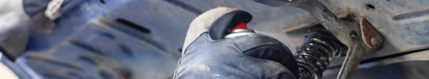 Technician lubricating a car door hinge during routine service in Montpelier Vermont