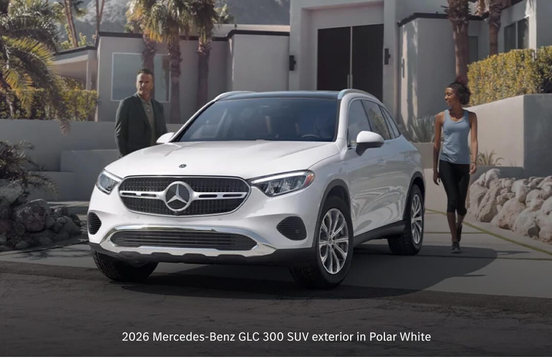 Front three-quarter view of 26 Mercedes GLC 300 in Polar White parked in a palm-lined desert residential driveway.