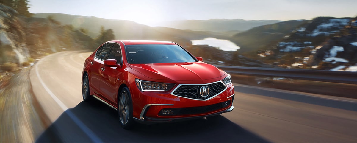 Red Acura RLX driving down the road