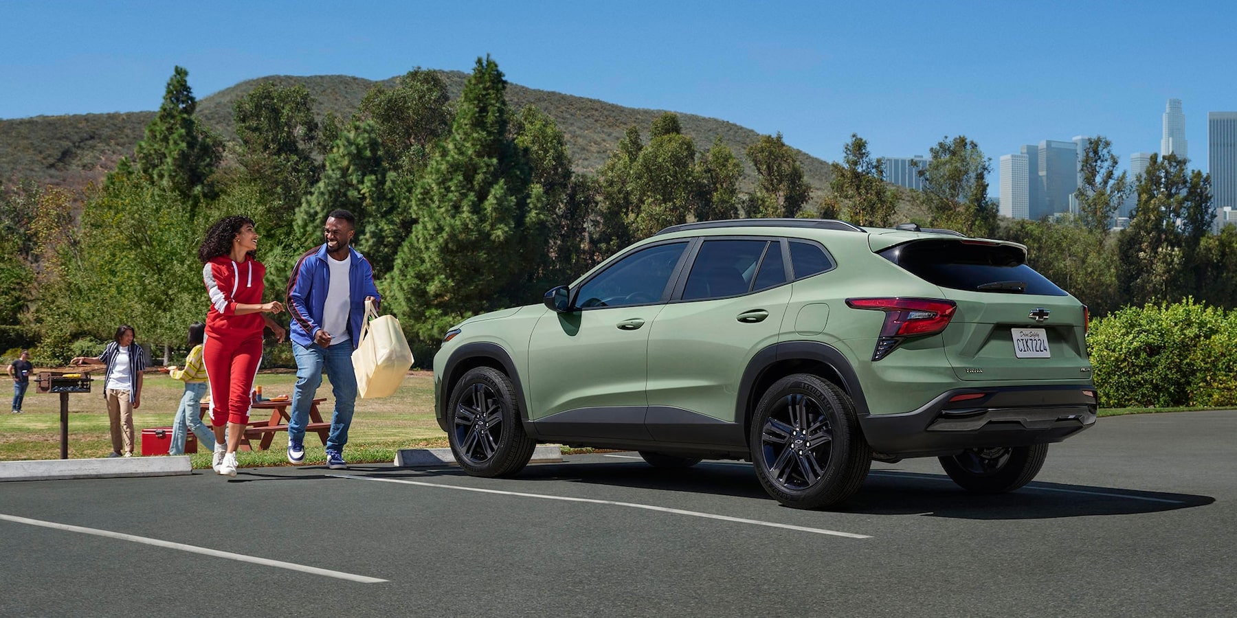 Happy couple walking to their parked Chevy Trax.