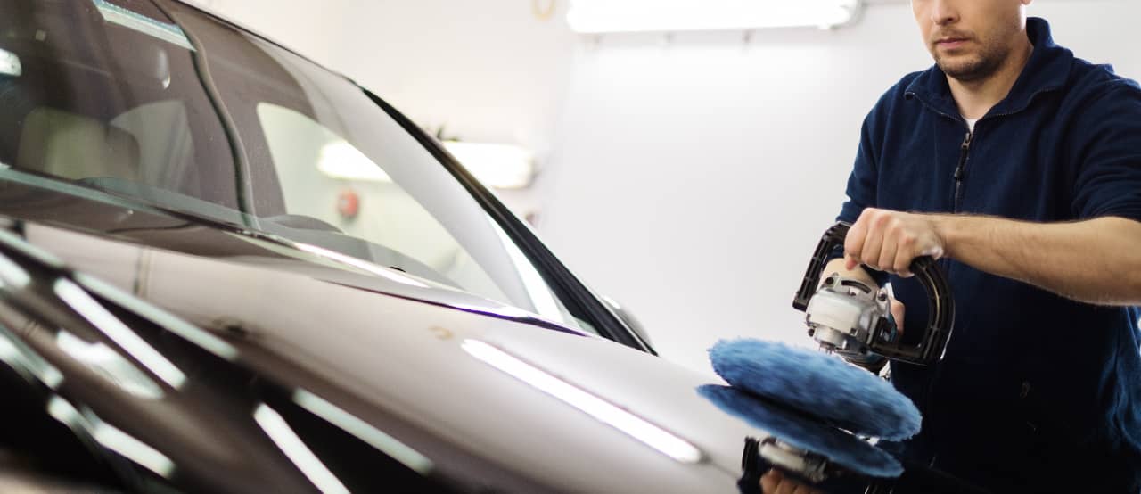 man polishes car paint