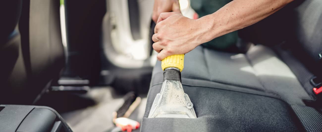 man deep cleaning leather seats