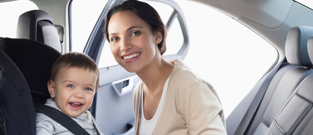 Woman securing infant in child seat