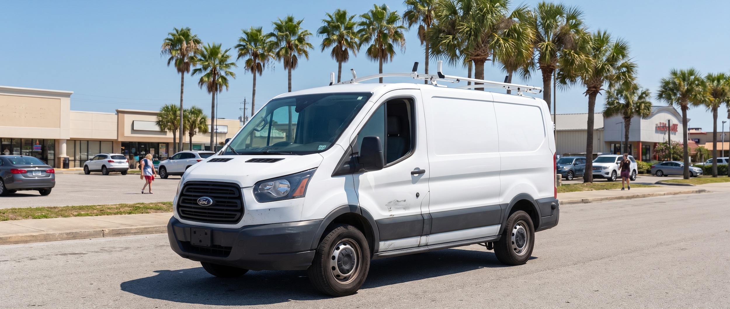 A used white cargo van parked on a sunny urban street in Panama City, Florida, with a flat road and palm trees visible in the background on a hot summer day, representing a work van commuter on the Gulf Coast Panhandle