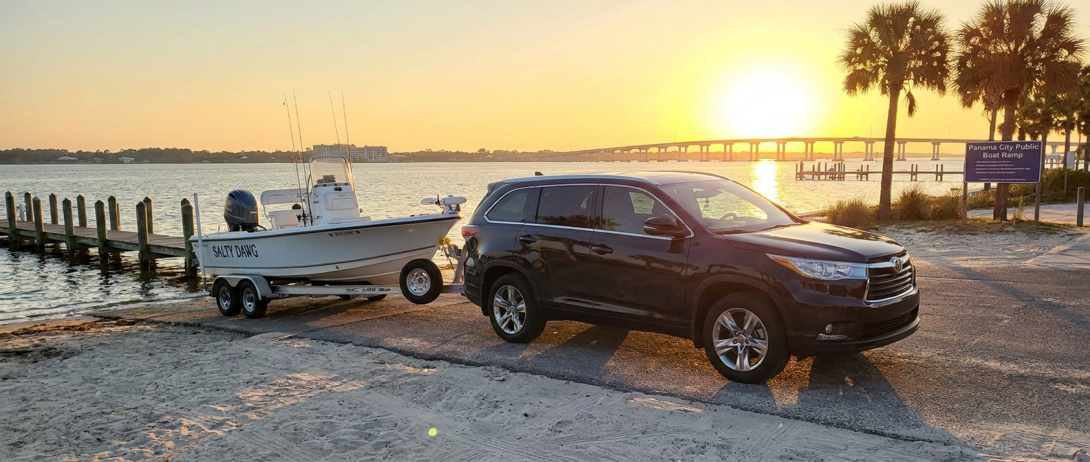 Used three-row SUV towing a bay boat at a public boat ramp on St. Andrews Bay near Panama City, FL