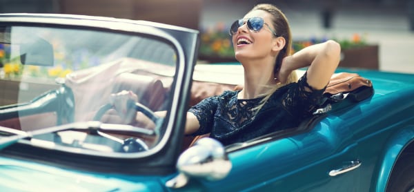 Woman driving convertible vehicle with top down