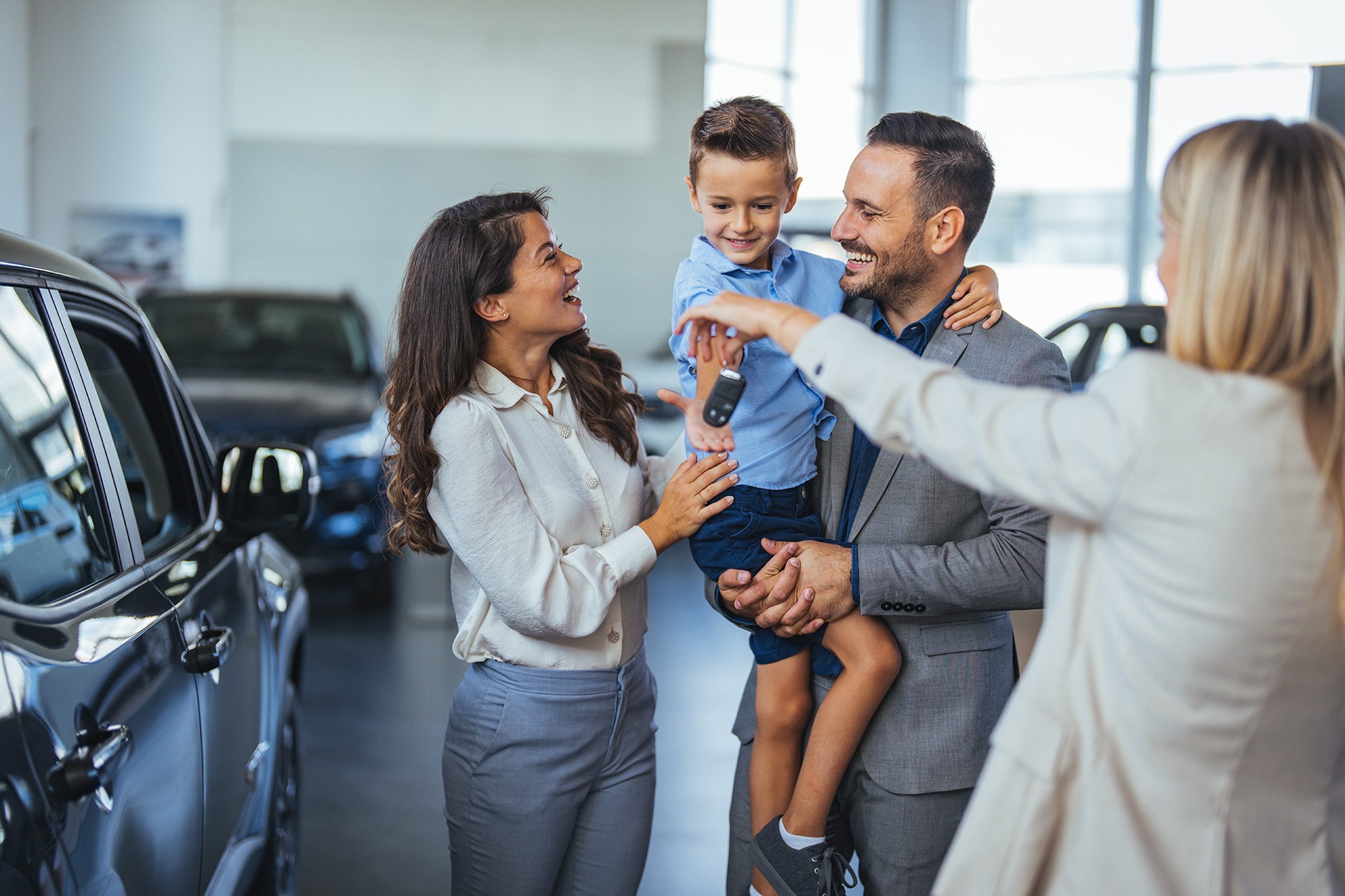 Happy family buying a car from a used car dealer 