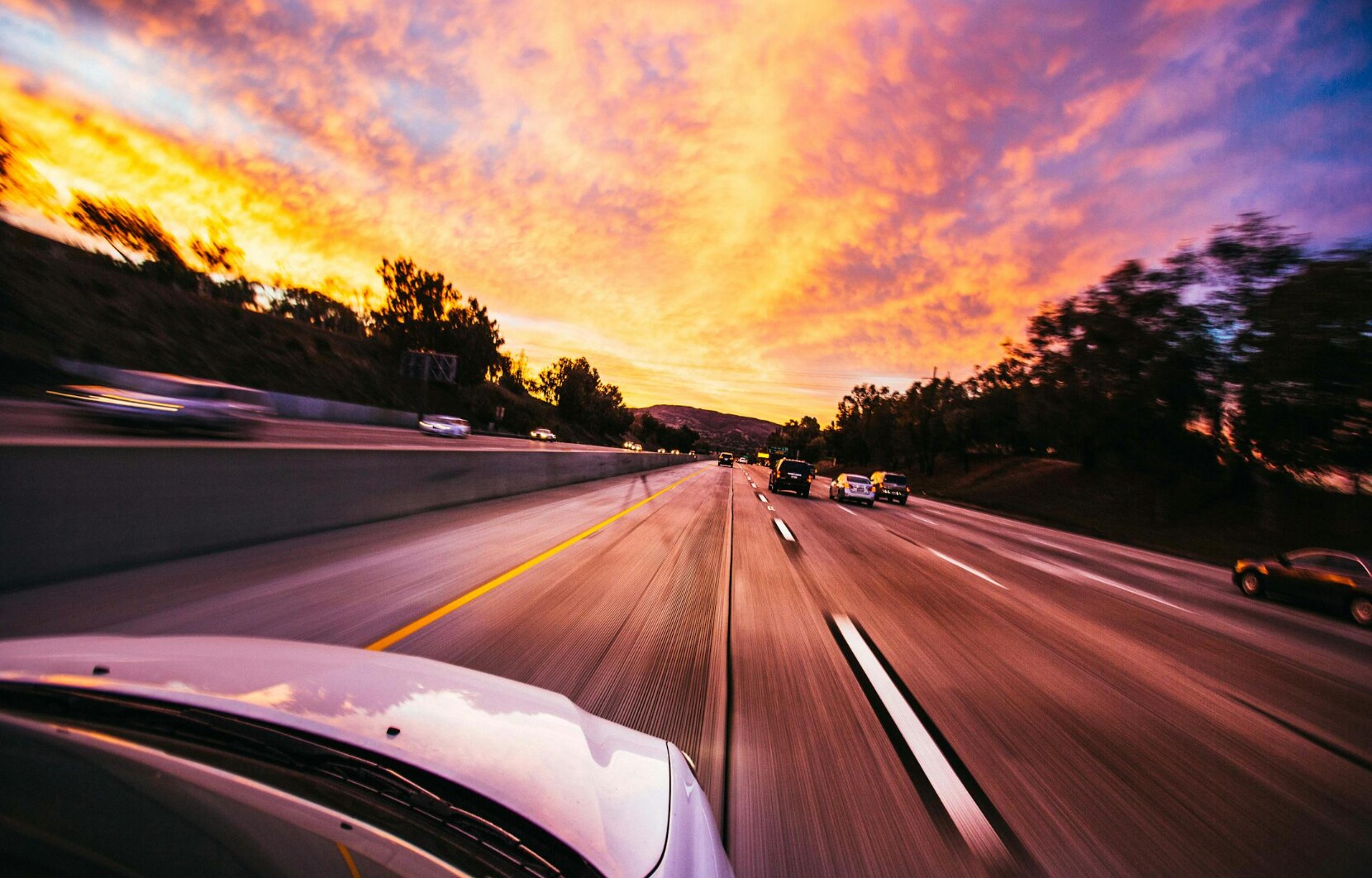 POV in the car driving down a highway at sunset POV in the car driving down a highway at sunset