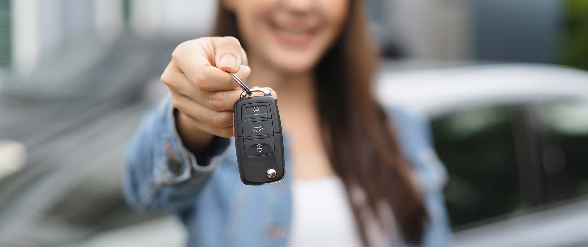 Special Vehicle Offers Near Struthers, OH Young woman showing the key to her newly purchased vehicle