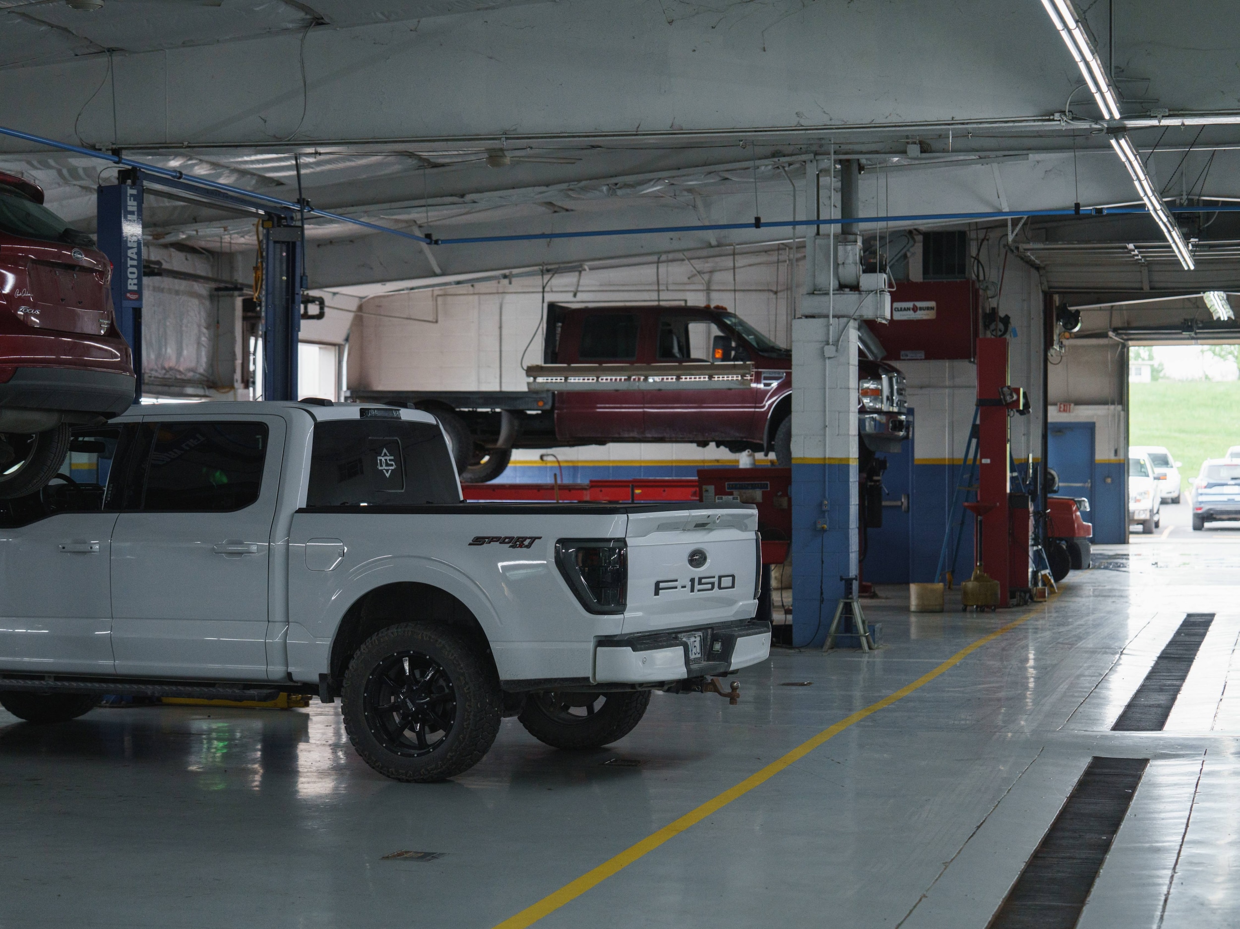 Technician inspecting vehicle fluids and underhood components