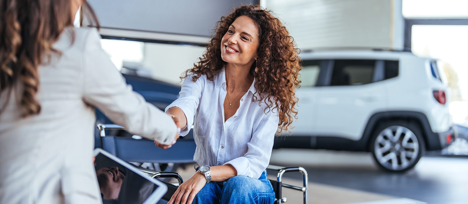 Happy woman shakes hands with a sales representative